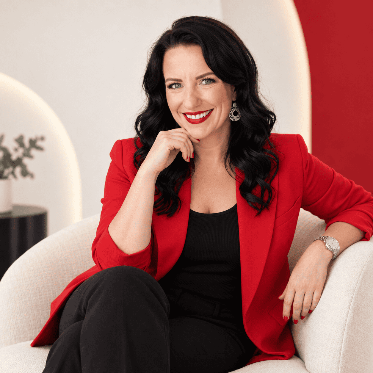Monica Froese in a red blazer, seated and smiling